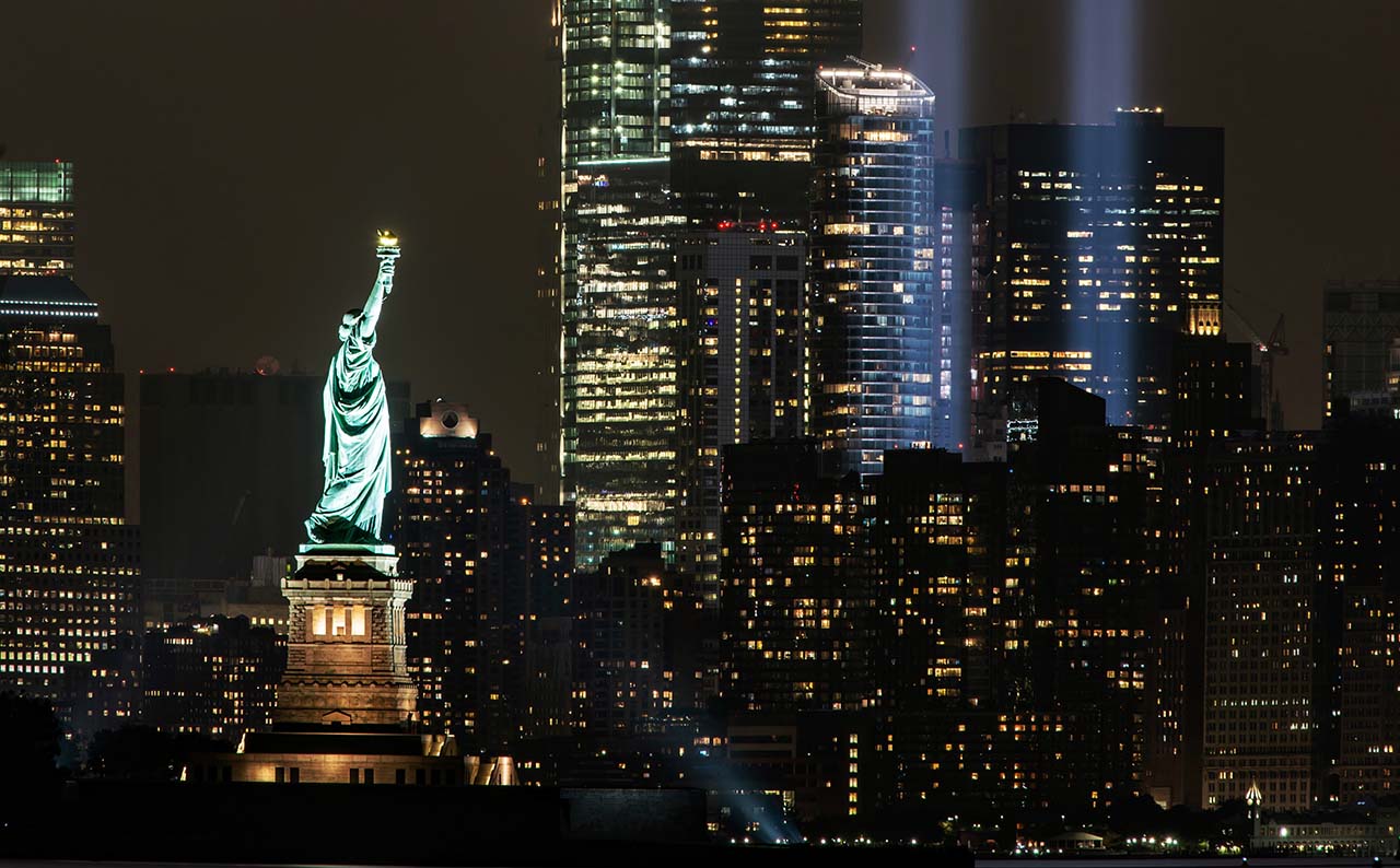 La estatua de la libertad junto con los haces de luz que recuerdan las Torres Gemelas en Nueva York